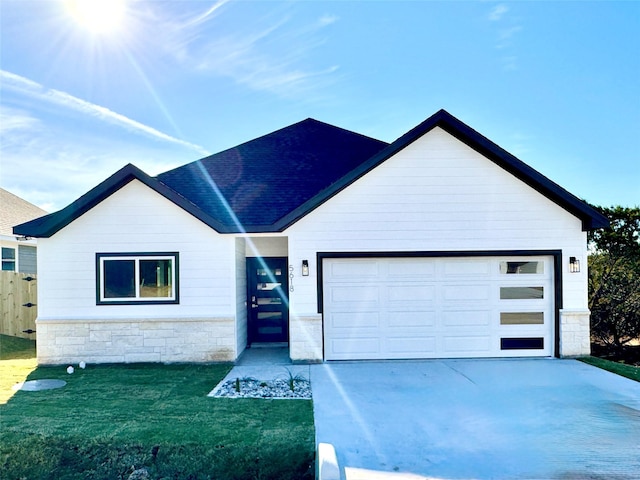 view of front of property with a garage and a front lawn