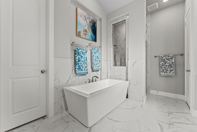 bathroom with tile walls, a tub to relax in, and vaulted ceiling