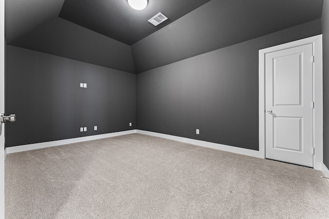 bonus room with a textured ceiling, vaulted ceiling, and carpet flooring