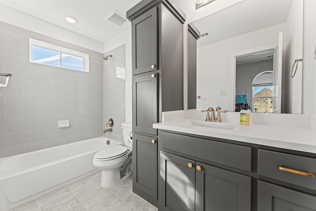 full bathroom featuring vanity, tile patterned flooring, tiled shower / bath combo, and toilet