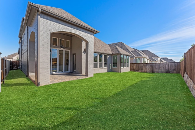 rear view of house featuring a patio area and a yard