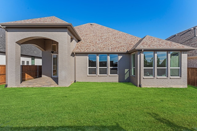 rear view of property with a patio and a yard