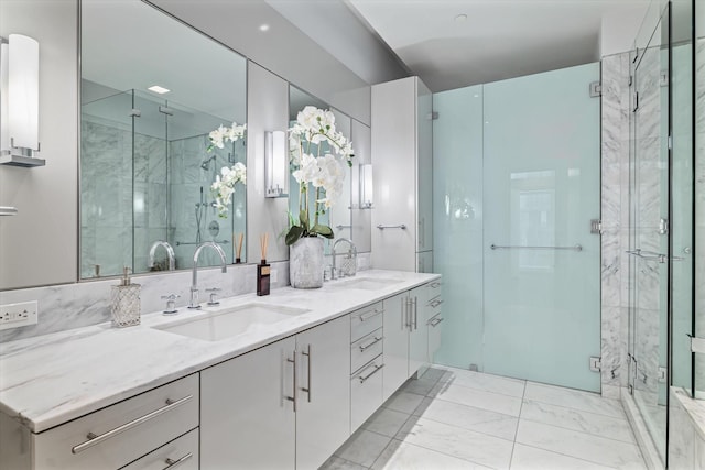 bathroom featuring a shower with door and vanity