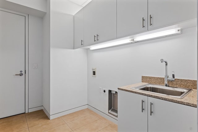 clothes washing area featuring cabinets, hookup for an electric dryer, washer hookup, sink, and light tile patterned flooring