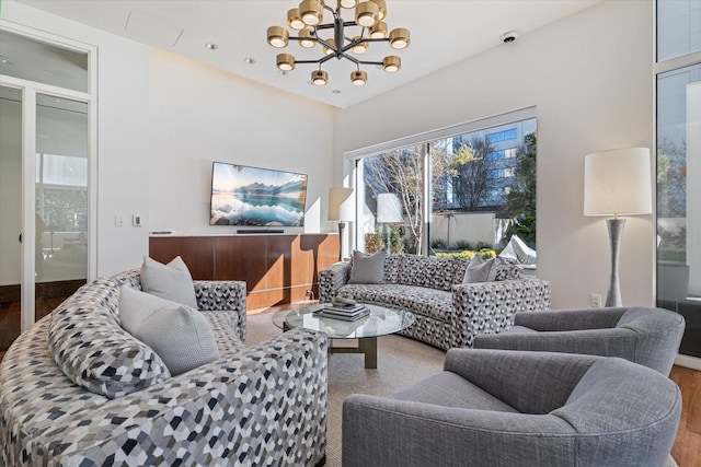 living room with a notable chandelier, a healthy amount of sunlight, and wood-type flooring