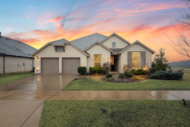 view of front of home featuring a garage and a lawn