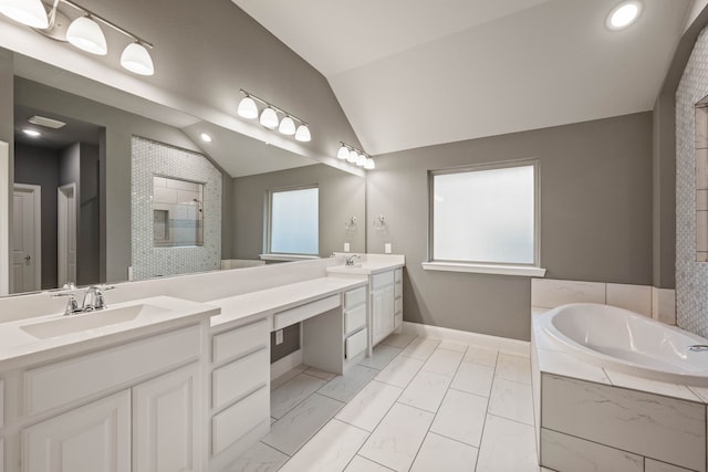 bathroom featuring lofted ceiling, vanity, and a relaxing tiled tub