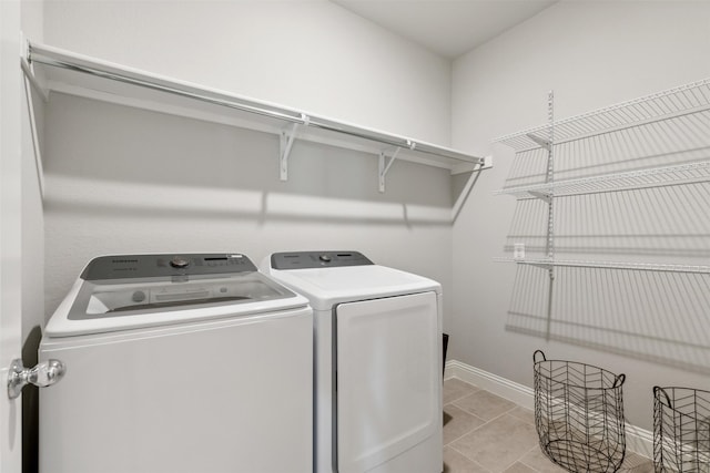 laundry area featuring light tile patterned floors and washing machine and dryer