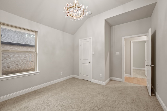 unfurnished bedroom featuring lofted ceiling, a notable chandelier, multiple windows, and carpet flooring