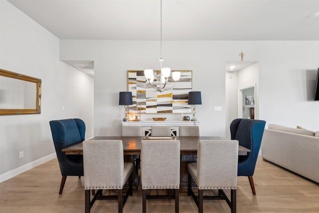 dining space featuring hardwood / wood-style flooring and a chandelier