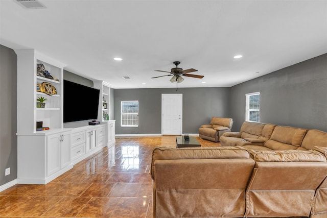 tiled living room with built in features, ceiling fan, and a wealth of natural light