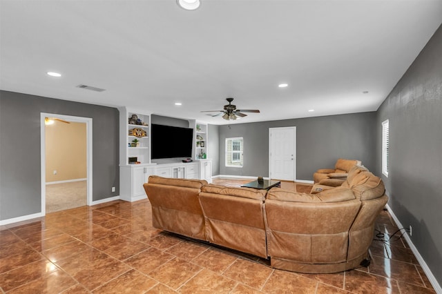 living room with built in shelves and ceiling fan