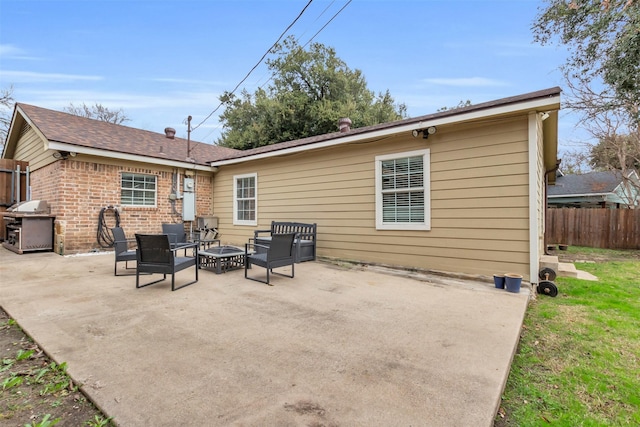 back of property with a fire pit and a patio area