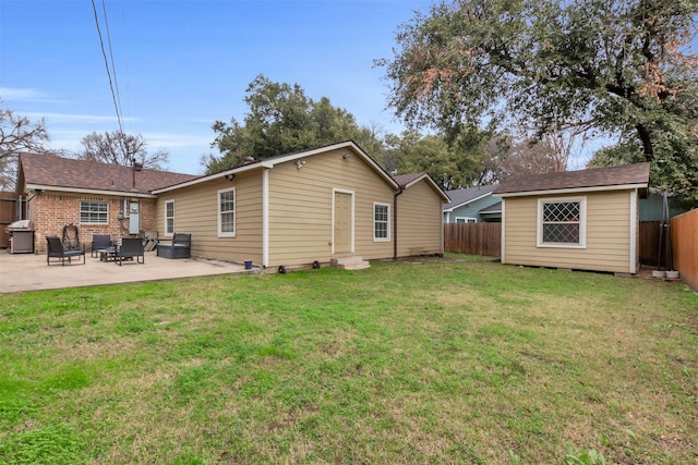 back of house with a patio, a lawn, and an outdoor structure