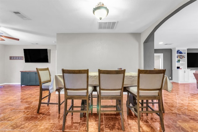 dining space featuring tile patterned floors and built in shelves