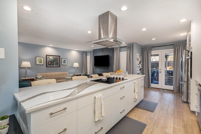 kitchen featuring island exhaust hood, french doors, white cabinets, and black electric cooktop