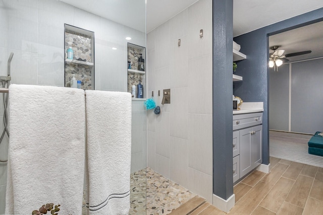 bathroom with ceiling fan, walk in shower, and vanity