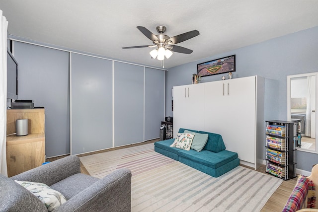 living room featuring light wood-type flooring and ceiling fan