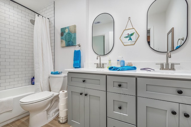 full bathroom featuring vanity, shower / bath combo with shower curtain, and toilet