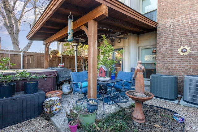 view of patio / terrace featuring central air condition unit, a hot tub, and ceiling fan