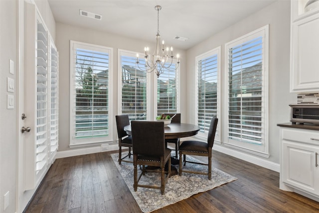 dining area with a notable chandelier and dark hardwood / wood-style floors