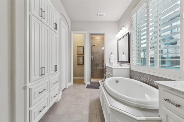 bathroom with shower with separate bathtub, vanity, and tile patterned flooring