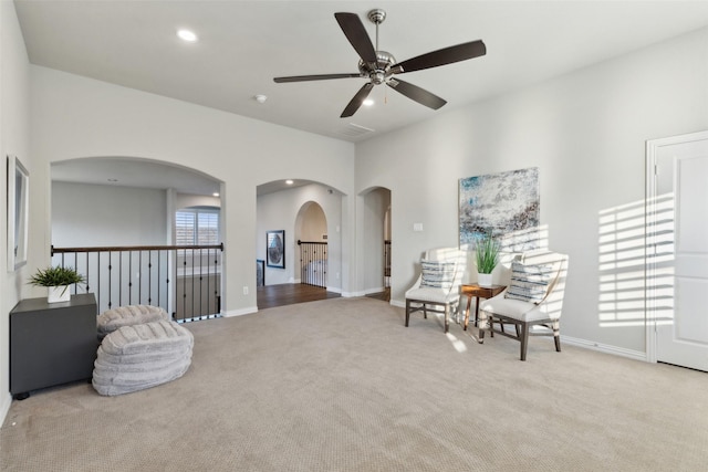 living area featuring ceiling fan and light colored carpet