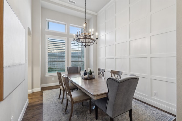 dining room with ornamental molding, a notable chandelier, and dark hardwood / wood-style floors