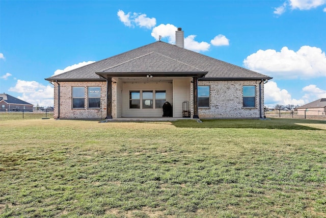 rear view of property with a yard