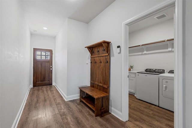 mudroom with dark wood-type flooring and washing machine and dryer