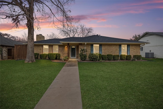 single story home featuring a yard and central AC unit