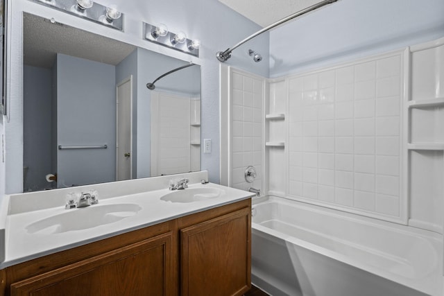 bathroom with a textured ceiling, shower / bathtub combination, and vanity