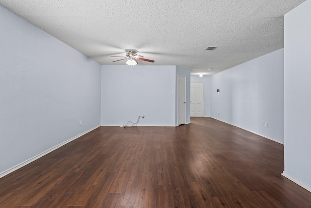 empty room with ceiling fan, dark wood-type flooring, and a textured ceiling