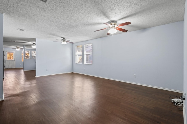 unfurnished living room featuring dark wood-type flooring and a textured ceiling