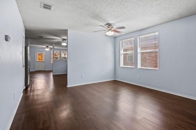 spare room with a textured ceiling and dark wood-type flooring