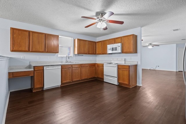 kitchen featuring sink, white appliances, dark hardwood / wood-style flooring, and a textured ceiling