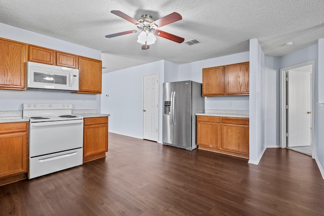 kitchen featuring ceiling fan, dark hardwood / wood-style flooring, white appliances, and a textured ceiling