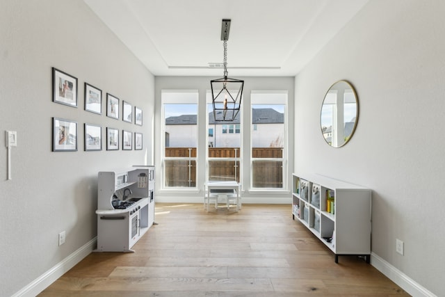 sitting room with light hardwood / wood-style floors and a chandelier