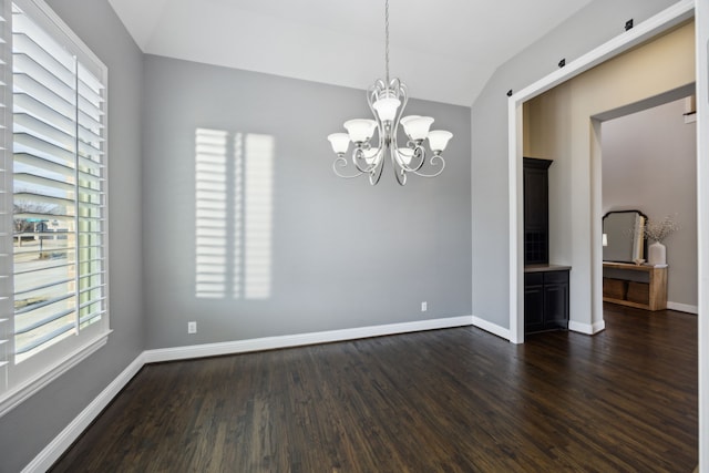 unfurnished room featuring lofted ceiling, an inviting chandelier, dark wood finished floors, and baseboards