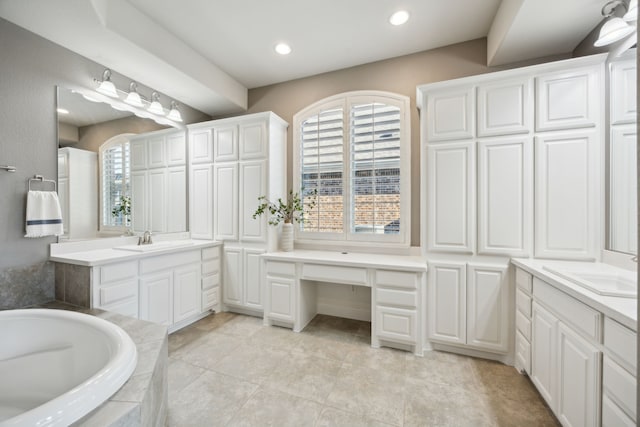 full bathroom featuring recessed lighting, two vanities, a sink, and a bath