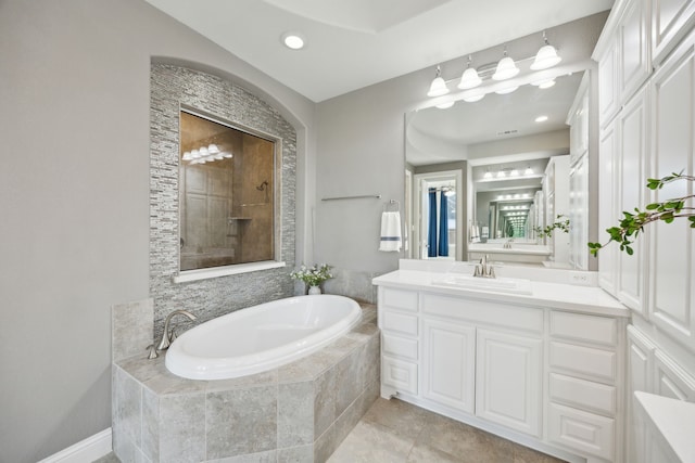 bathroom with recessed lighting, a tile shower, vanity, a bath, and tile patterned floors