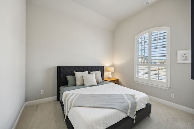 bedroom with lofted ceiling, light colored carpet, visible vents, and baseboards