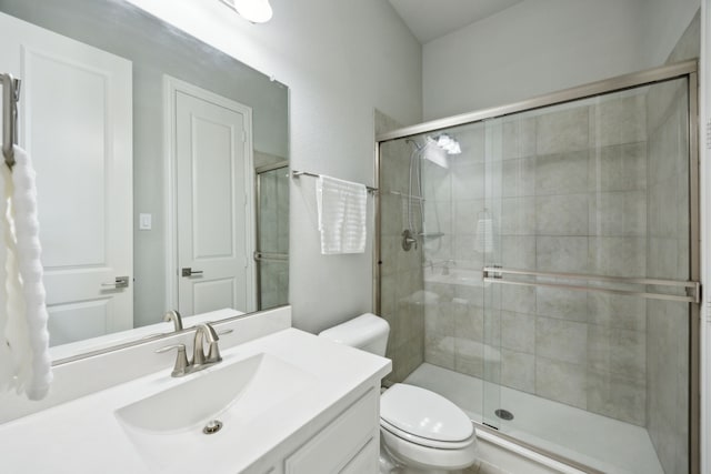 bathroom with toilet, walk in shower, and vanity