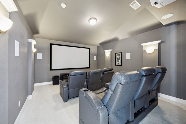 home theater featuring light colored carpet, visible vents, lofted ceiling, and baseboards