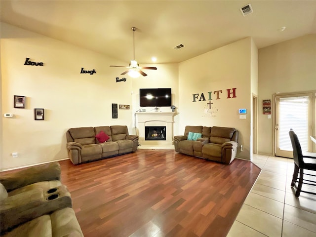 living room with ceiling fan, wood-type flooring, and vaulted ceiling