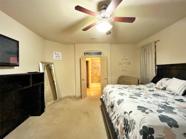 carpeted bedroom featuring ceiling fan and ensuite bath