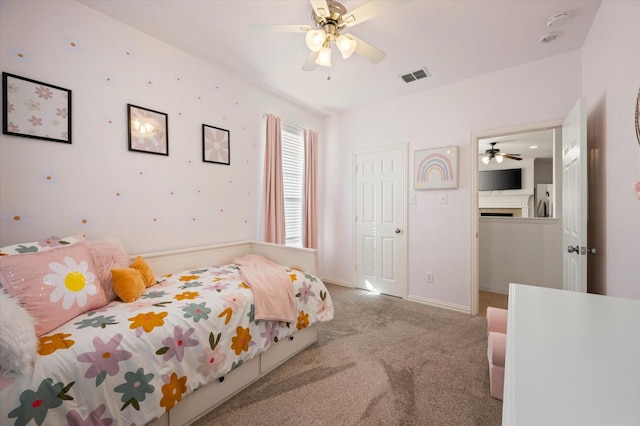 bedroom featuring ceiling fan, light carpet, and refrigerator