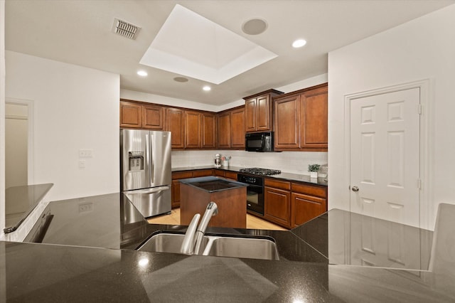 kitchen with decorative backsplash, sink, black appliances, and kitchen peninsula