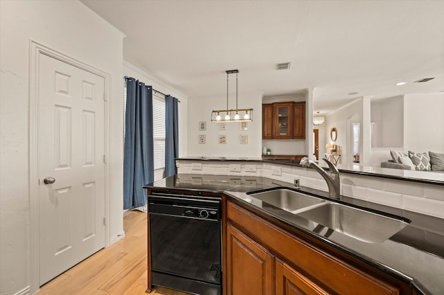 kitchen with decorative light fixtures, sink, black dishwasher, and light hardwood / wood-style flooring