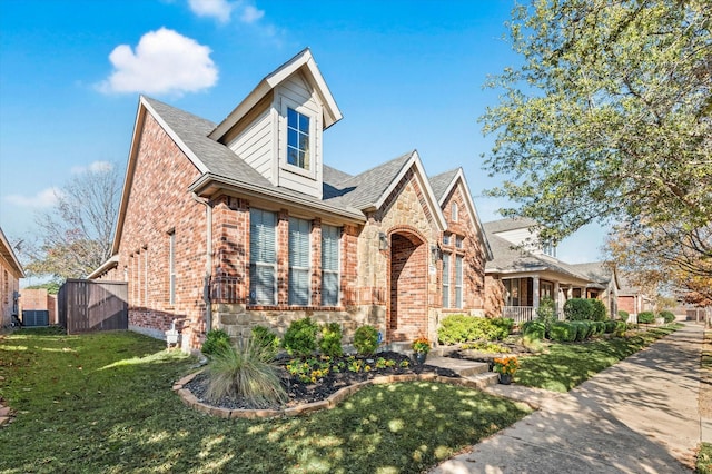 view of front of home with a front yard and central AC unit